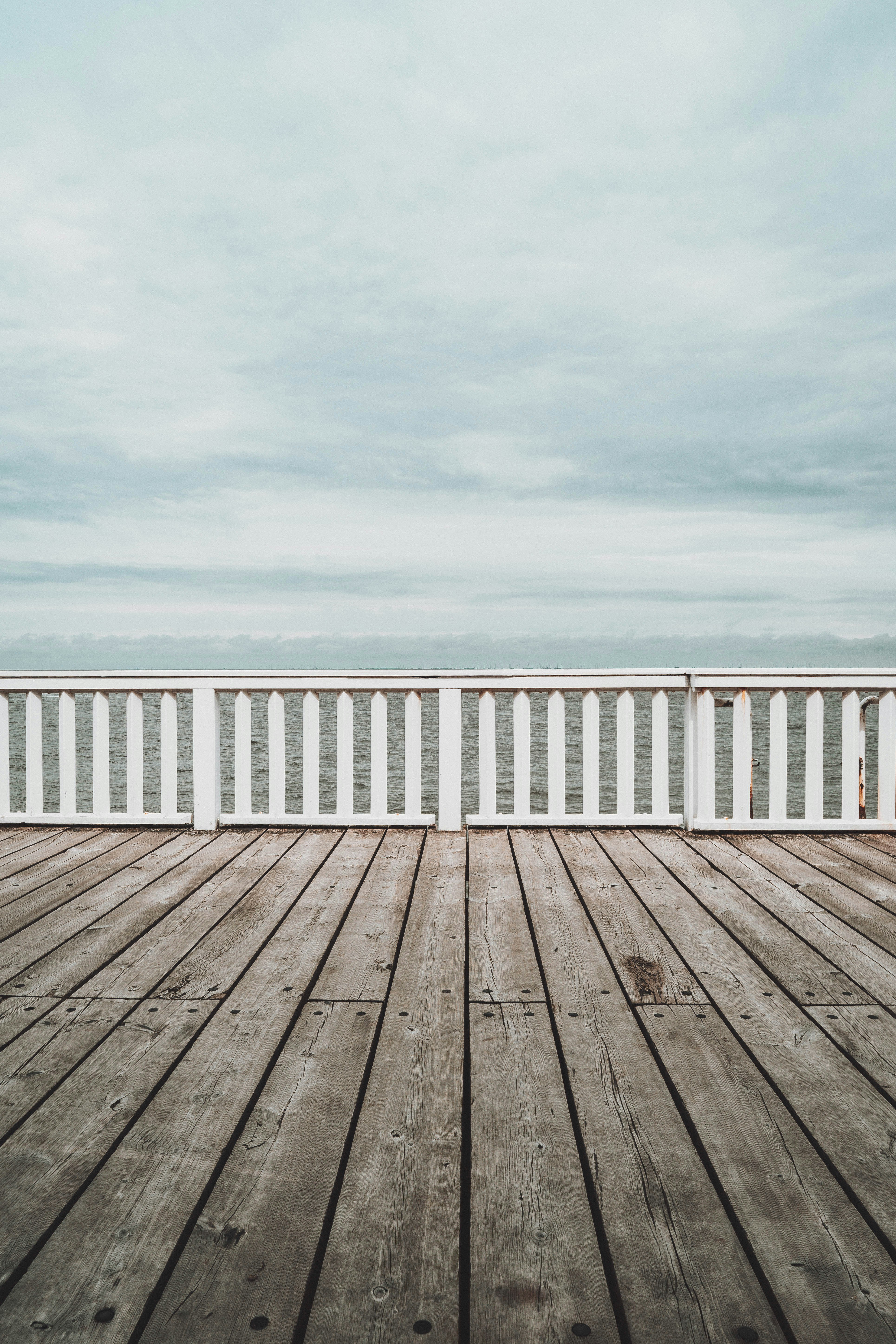 white wooden dock under white cloudy sky during daytime